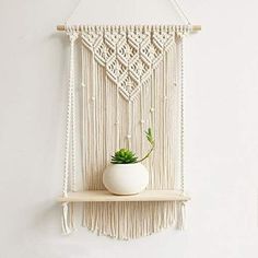 a macrame wall hanging with a potted plant