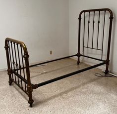 an old iron bed frame with no headboard and foot board is shown in this empty room