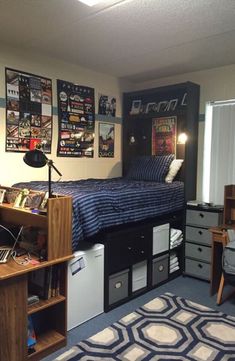 a dorm room with a bed, desk and computer on top of the dressers