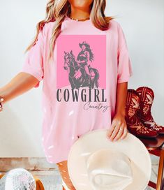 "Embrace your inner cowgirl in this beautiful Cowgirl Country Comfort Colors shirt!   Want a different design or color? Just let us know and we'll make it happen!  FIT & SIZING: * These beautiful and trendy Comfort Colors t-shirts bring extra coziness to your wardrobe, while the relaxed fit makes them an excellent daily choice.  * Comfort Colors shirts are made in the USA. * Please see the size chart in the photos to obtain an accurate size. Measure one of your favorite tees for comparison! * Ladies: These tees are unisex sizes. Your normal size will fit a bit loosely. For a snug fit, order one size down from your normal size. For an oversized fit, size up. The \"t-shirt dress\" look is attained by sizing up at least two sizes. GARMENT FEATURES: * 100% combed and ring-spun cotton  * Double Cowgirl Outfits, Outfit Cowgirl, Cowgirl Outfit, Cowgirl Costume, Western Graphic Tees, Pink Cowgirl, Cowgirl Shirts, Country Shirts, Comfort Colors