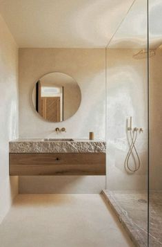 a bathroom with a sink, mirror and shower stall in it's center area