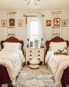 two twin beds in a bedroom with chandelier above them and rug on the floor