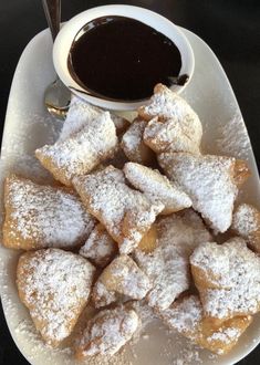 powdered sugar pastries on a plate with dipping sauce