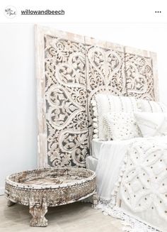 a white bed sitting next to a wooden headboard