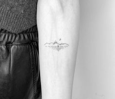 a woman's arm with a small tattoo on the left side of her arm