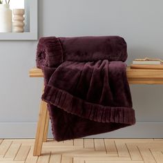 a purple blanket sitting on top of a wooden table