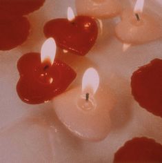 several candles with red hearts on them