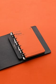 an orange notebook with a black cover