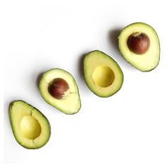 an avocado is cut in half on a white surface with three pieces missing