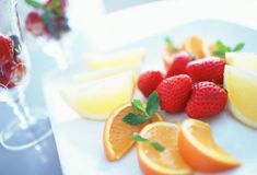 there are oranges, strawberries and lemons on the plate