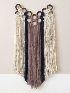 the wall hanging is decorated with different colored fringes and circular rings on it's sides