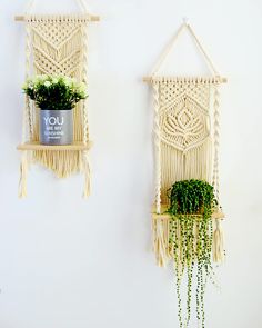 two macrame wall hangings with plants in them and one holding a potted plant