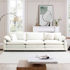 a living room filled with furniture and a large white couch in front of a window