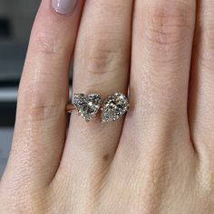 a woman's hand with two engagement rings on it