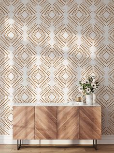 a sideboard with flowers on it in front of a wallpapered background that looks like diamonds