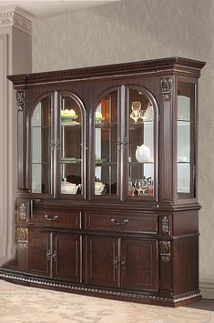 a wooden china cabinet with glass doors on the top and bottom, in a living room