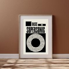 a framed poster with the words oasis supersonic in black and white on a brown wall