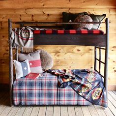 a wooden bunk bed with pillows and blankets on top of it next to a blanket