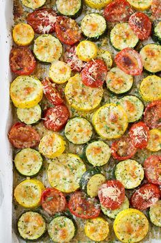 a casserole dish with tomatoes, zucchini and parmesan cheese