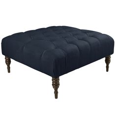 the footstool is made from dark blue velvet and has wooden legs, which are also