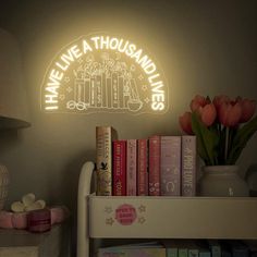 there is a shelf with books and flowers on it