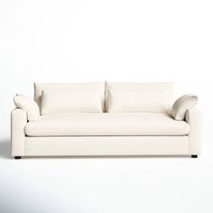 a white couch sitting on top of a white floor