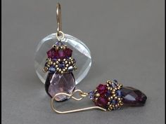 a pair of earrings with amethyst garnets and swaronite