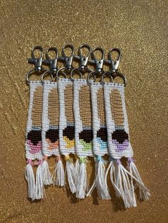 four crocheted key fobs with tassels hanging from them