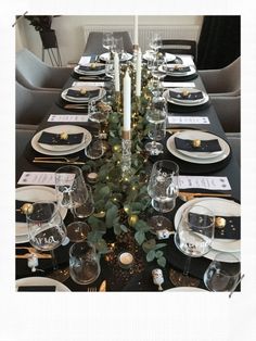 the table is set with black and gold place settings