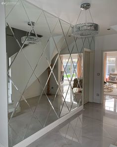 a large mirror in the middle of a room with a chandelier hanging from it's ceiling