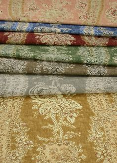 a stack of different colored fabrics on top of each other in various patterns and colors