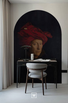 a painting with a red turban on top of it next to a desk