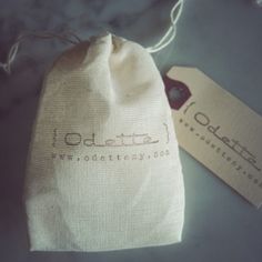 a small bag sitting on top of a table next to a tag with the word idolita written on it