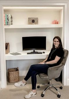 a woman sitting in an office chair next to a desk with a computer on it