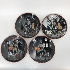 four decorative plates with skeletons on them are arranged in the shape of a skeleton riding a bike