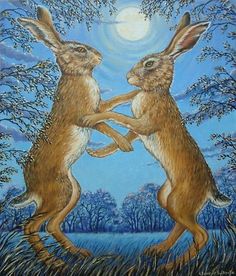 two brown rabbits playing with each other in front of a blue sky and tree background