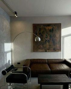 a living room filled with furniture and a painting on the wall