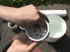 a person is pouring water into a white cup