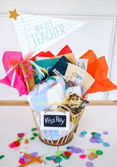 a basket filled with lots of books and confetti on top of a table