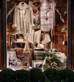 a window display with deer antlers and sweaters