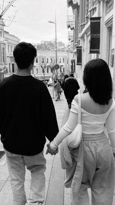 two people walking down the street holding hands