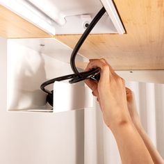 a person is plugging in to a wall outlet with a power cord and wires