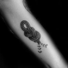 a black and white photo of a person's arm with an arrow tattoo on it