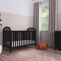 a baby crib in a room with a rug on the floor next to it