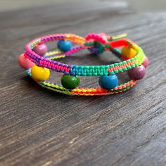 multicolored bracelets are sitting on a wooden table