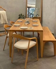 a wooden table with chairs and plates on it