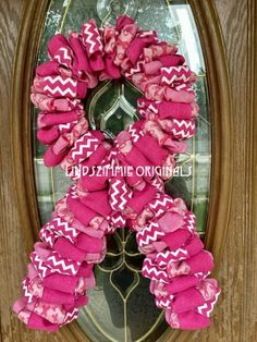 a pink and white wreath on the front door