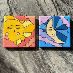 two small square paintings with sun and moon painted on them