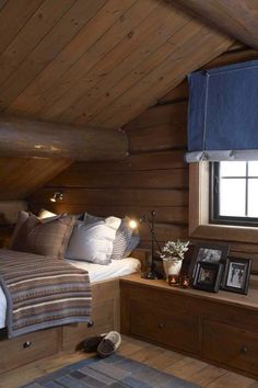 a bedroom with wood paneling and blue curtains on the window sill is shown