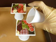 a person is pouring something into a cup on top of a table with other items